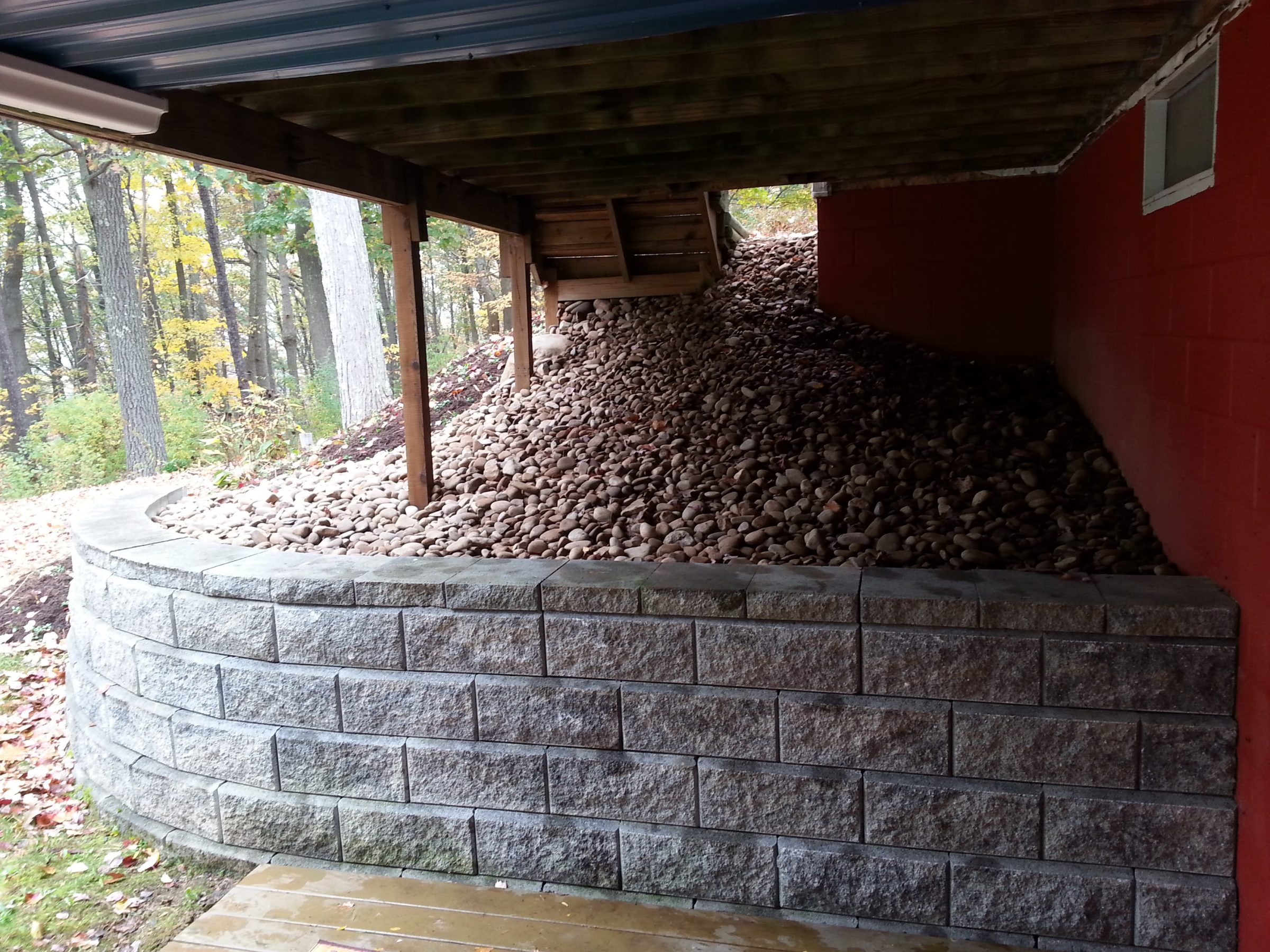 Retaining wall with river rocks under deck