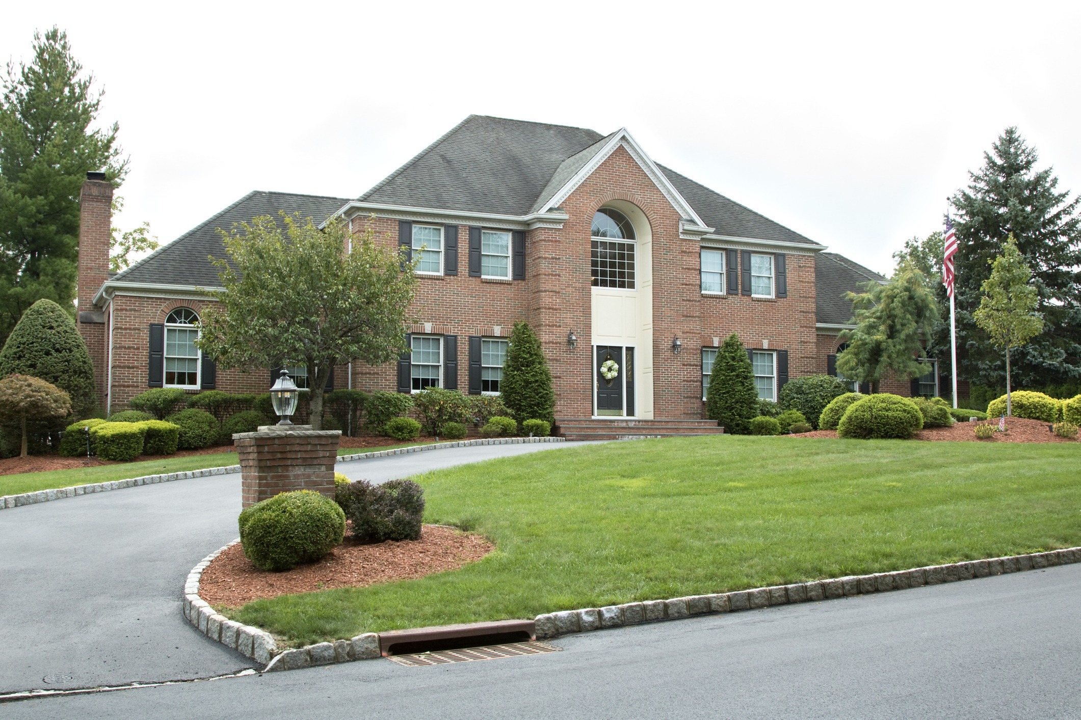 Elegant brick house with garden and driveway.
