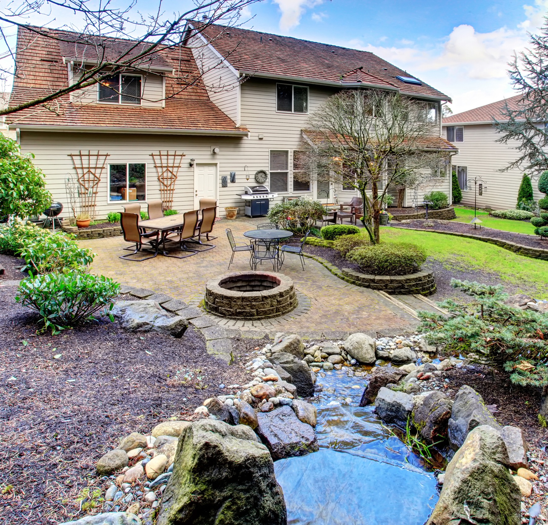 Backyard with patio, fire pit, and stream