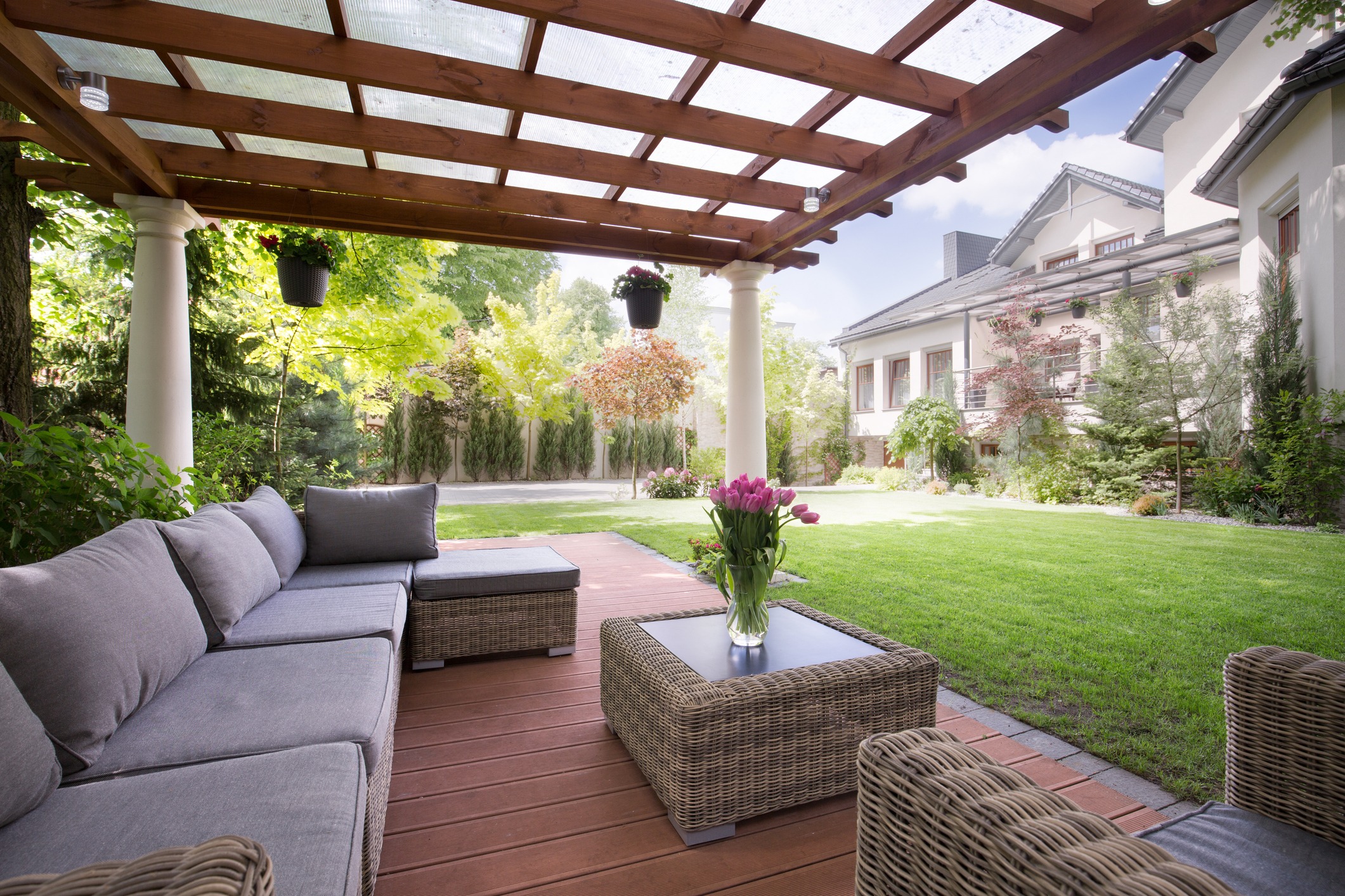 Covered patio with wicker furniture and garden view
