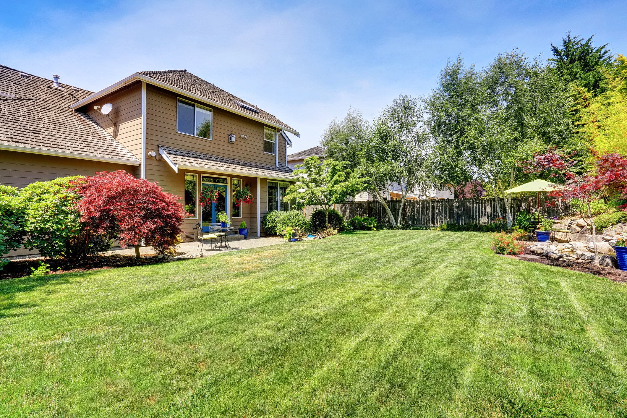 Backyard with lawn and patio furniture.