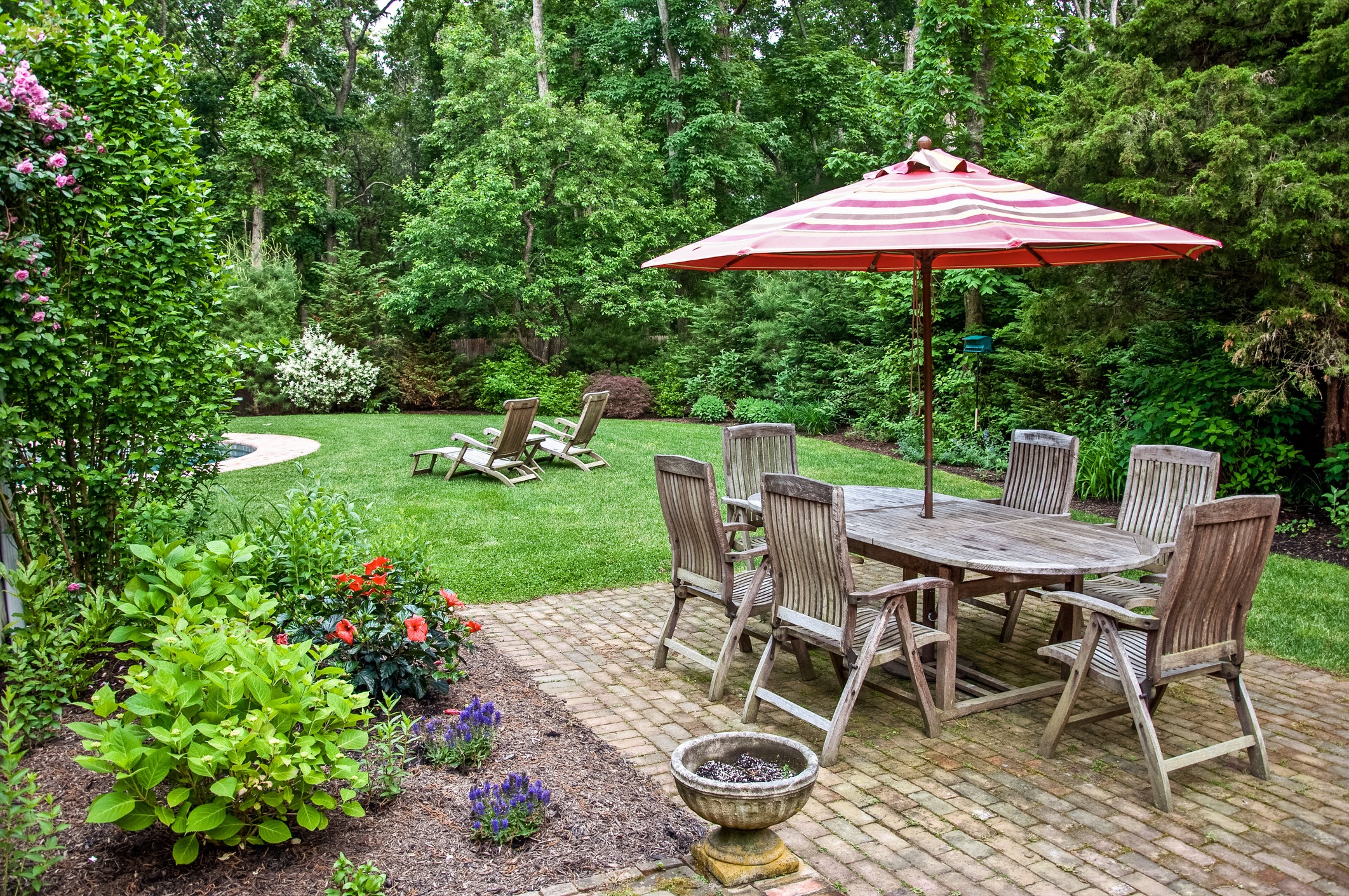 Outdoor patio with wooden furniture and lush garden