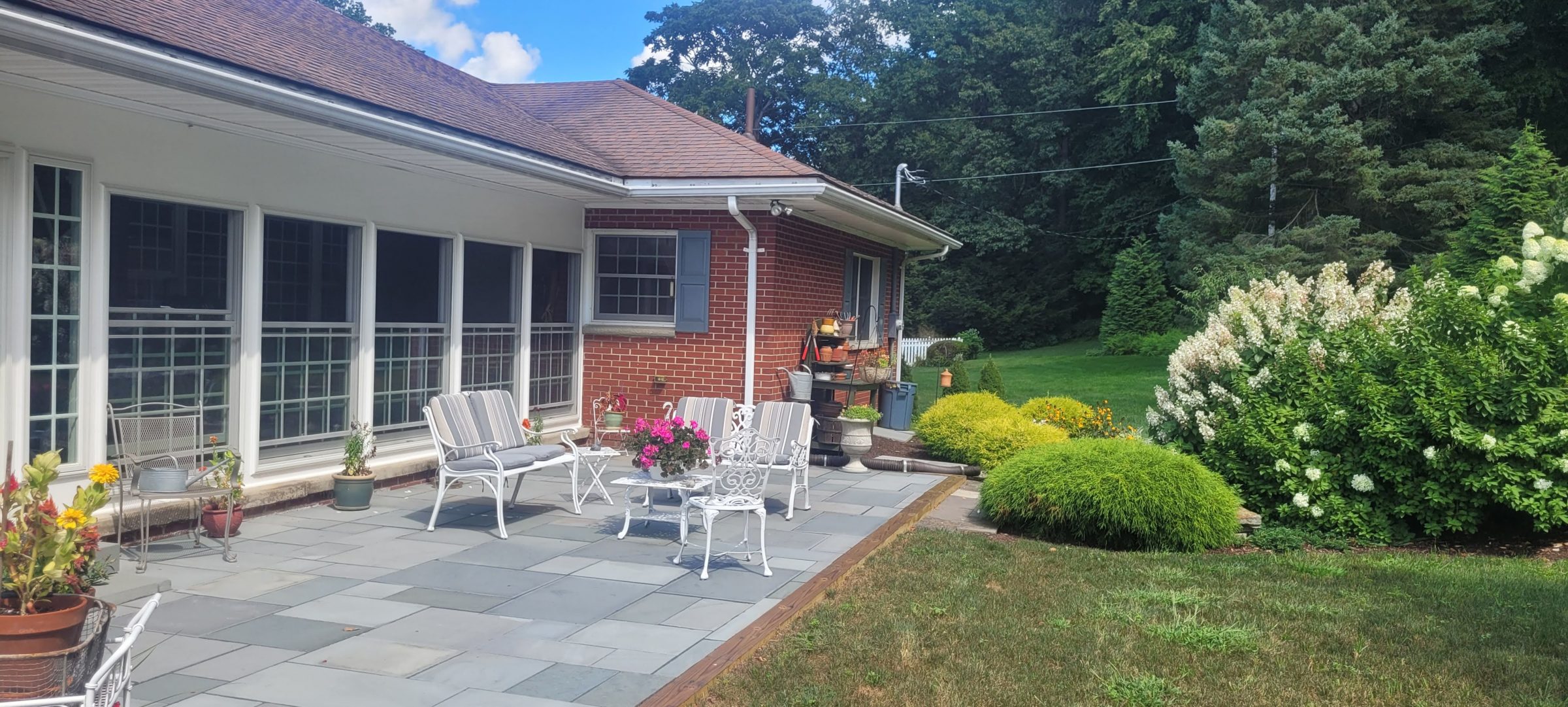 Patio with chairs and lush garden view