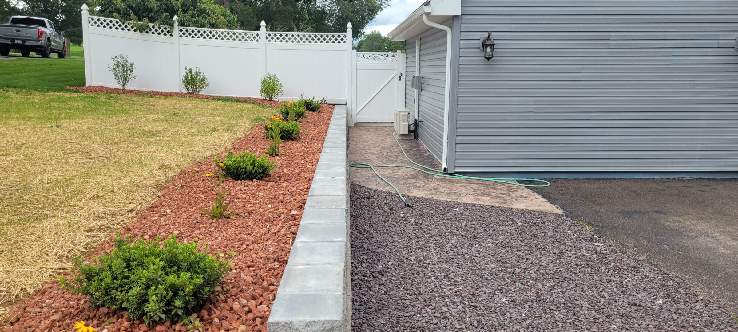 Landscaped backyard with stone border and shrubs
