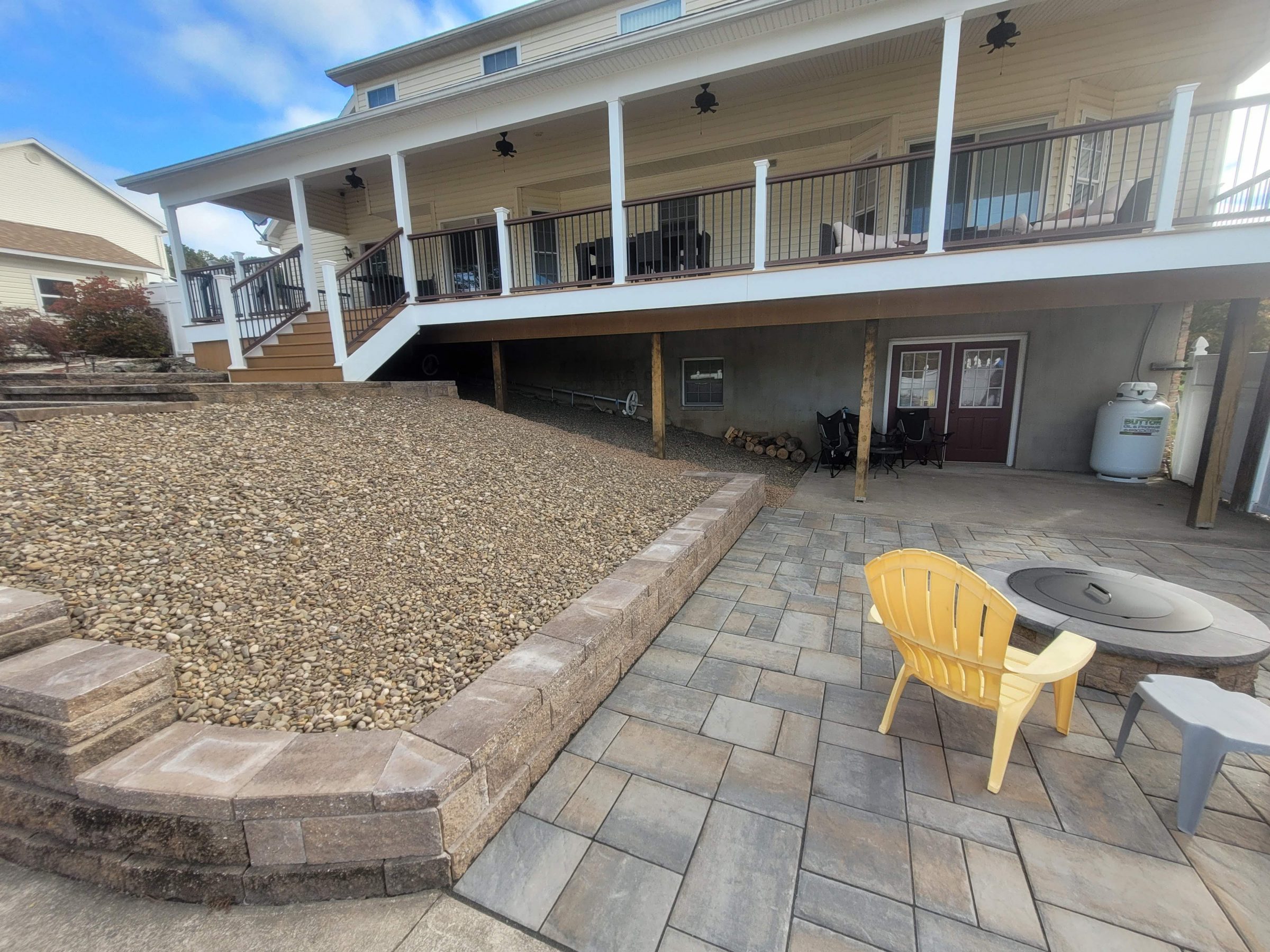 Backyard patio with fire pit and raised deck