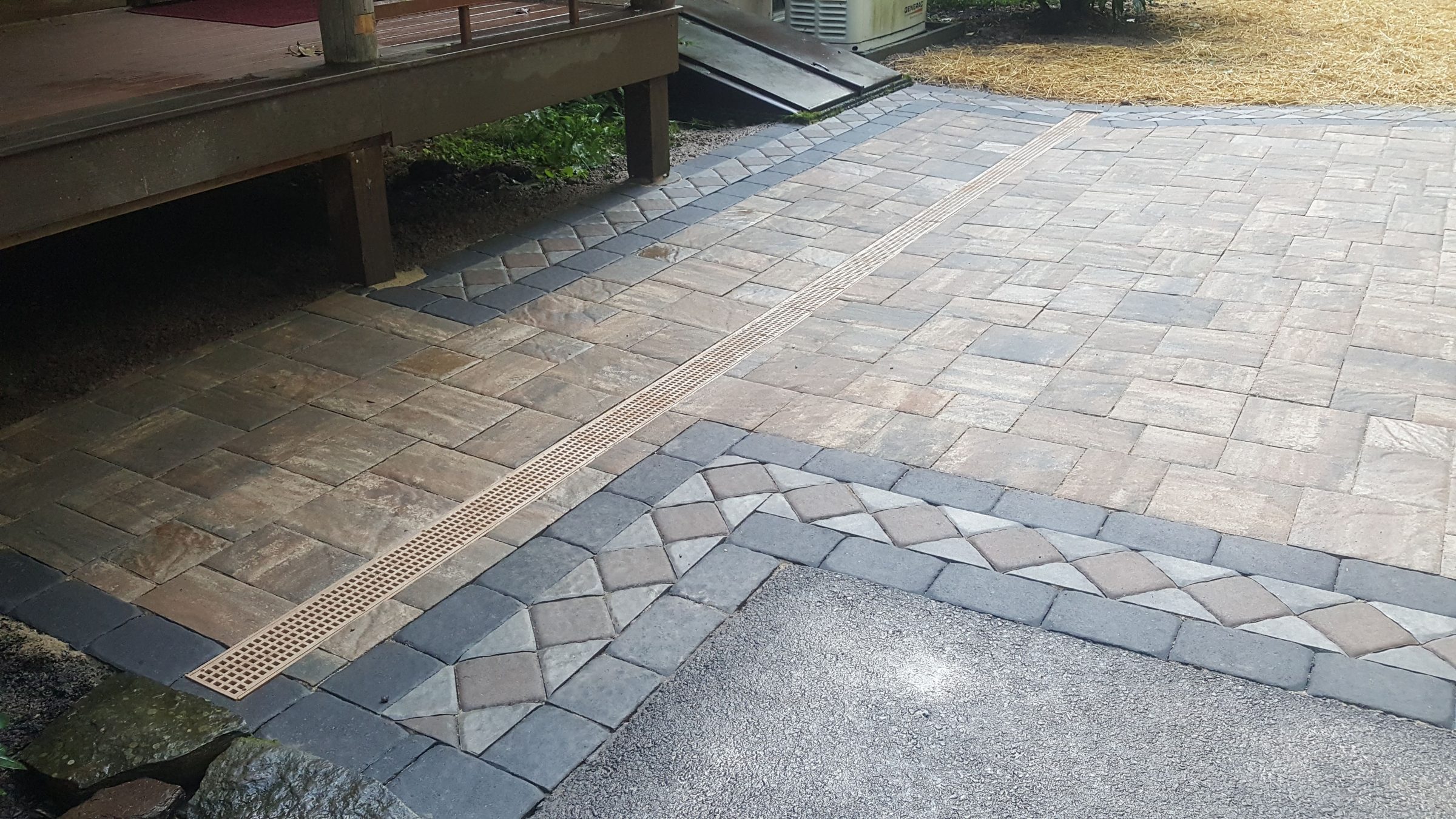 Paver patio with linear drain near deck