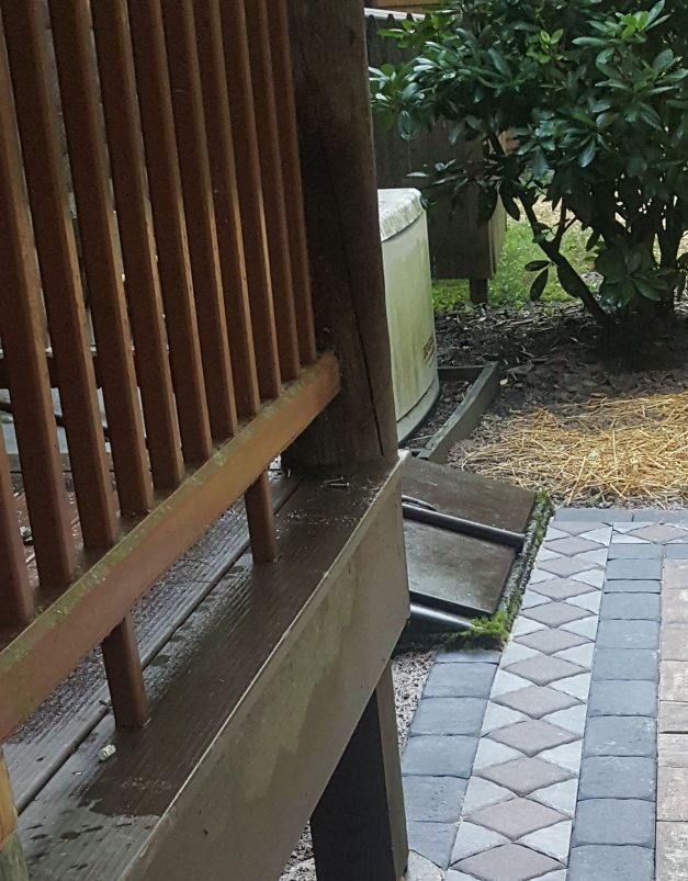Stone patio walkway with decorative border and drain