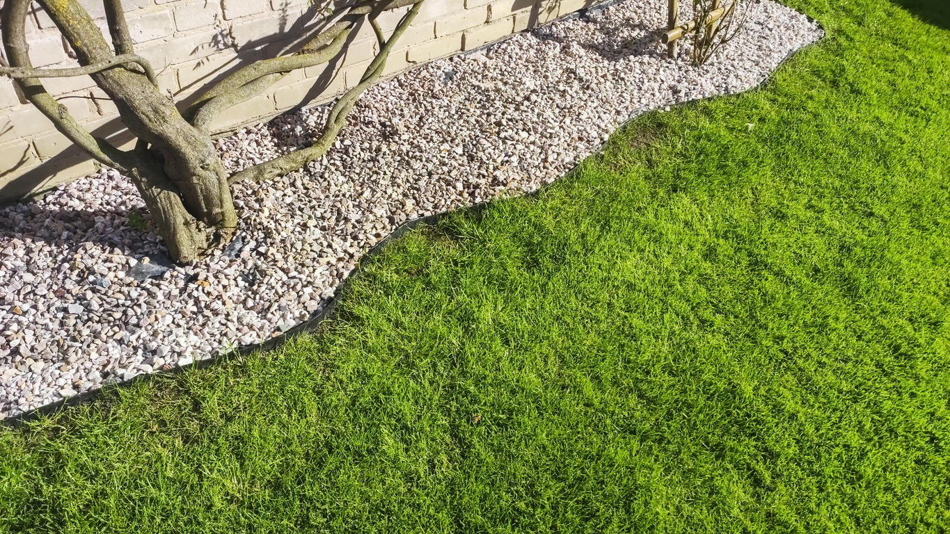 Green lawn bordered by gravel garden bed