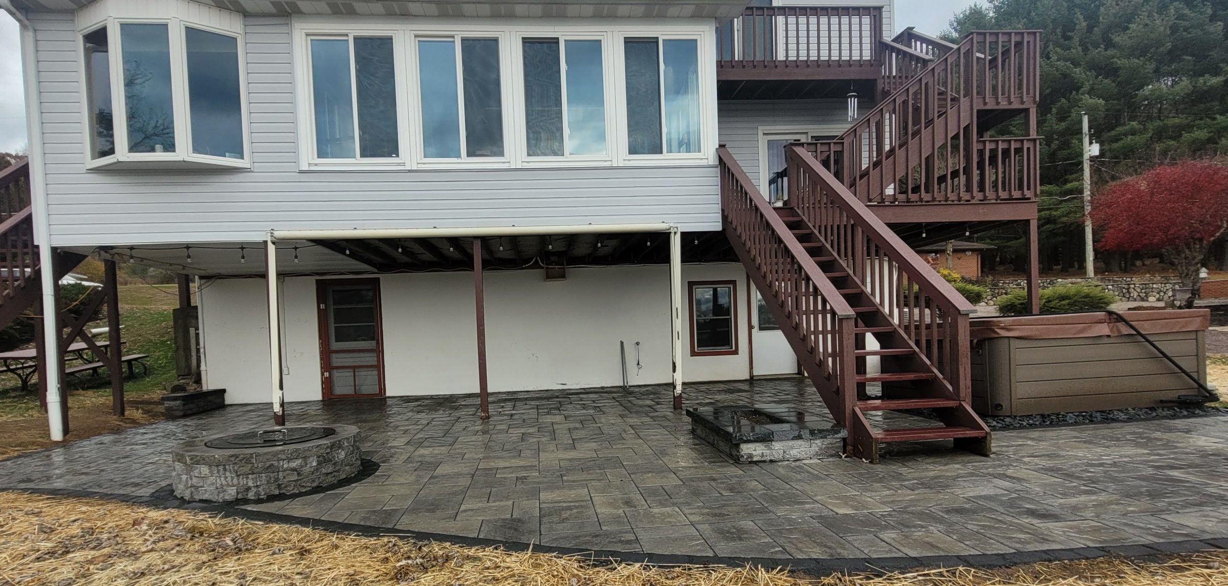 Backyard patio with deck, stairs, and fire pit