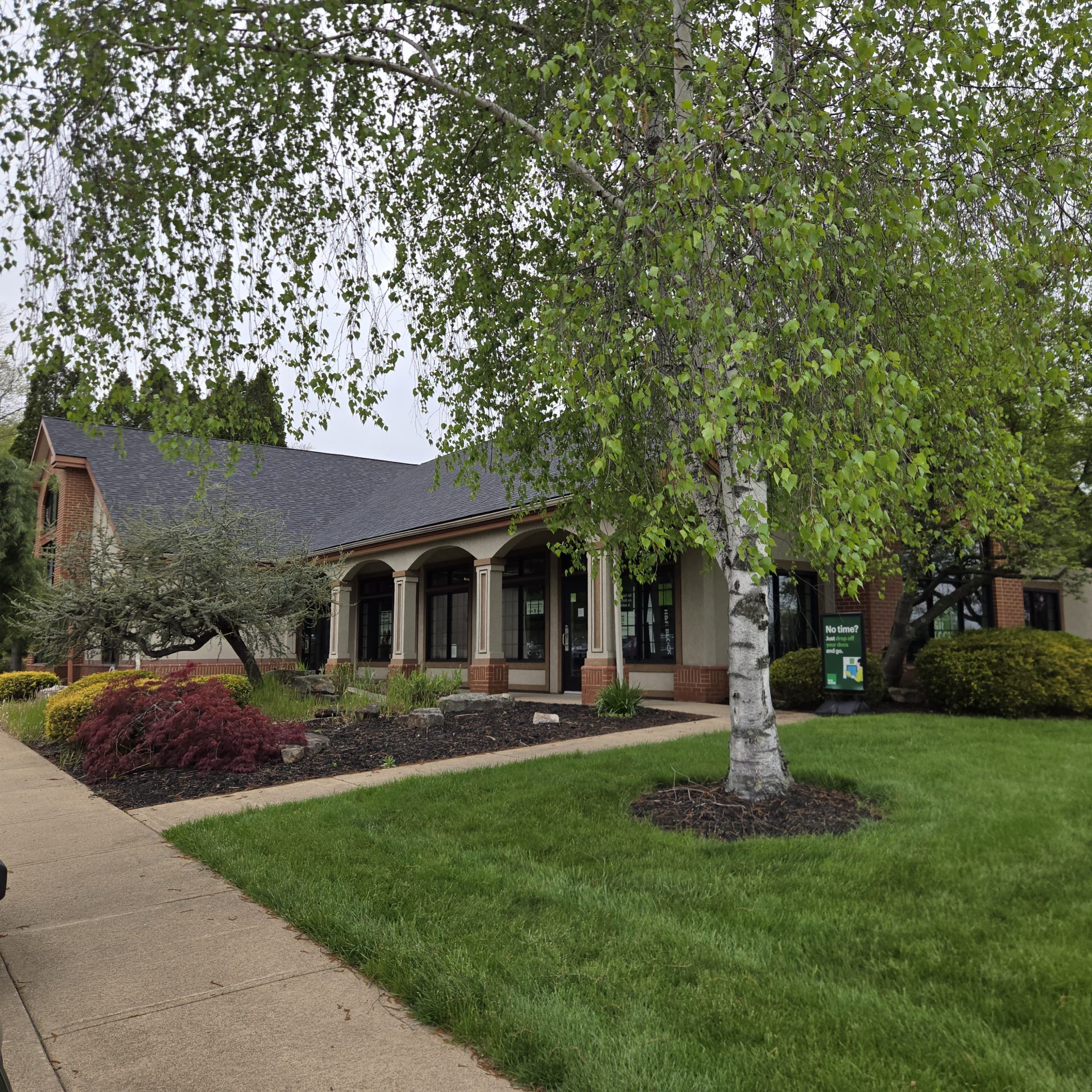 Brick office building with trees and landscaped lawn